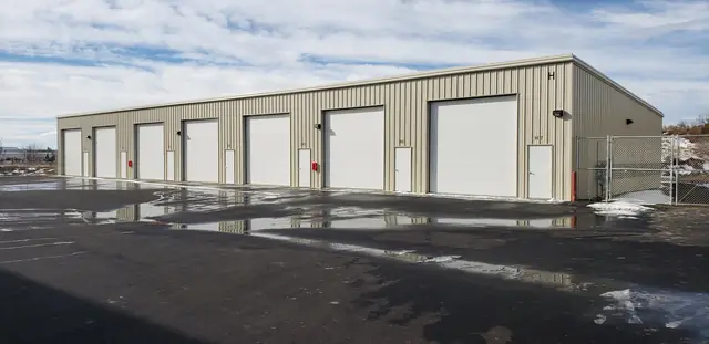 Enclosed storage building at SYT Storage with six overhead doors on a paved lot