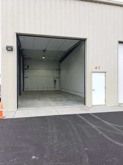 Open 14-foot overhead door on a 22 by 50 foot heated unit, with the private man door beside it