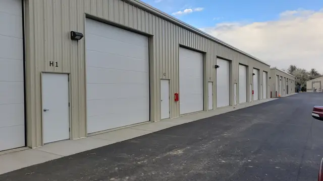 Row of SYT Storage units with tall 14-foot overhead doors and a separate man door beside each one